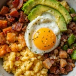 Low Carb Breakfast Bowls Recipe 3 Colorful low carb breakfast bowl with scrambled eggs, avocado, bacon, and veggies.