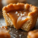 Salted Caramel Tart 3 Close-up of a salted caramel tart slice showing gooey caramel and flaky crust