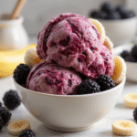 Blackberry Banana Ice Cream 5 Bowl of creamy blackberry banana ice cream with fresh berries and mint