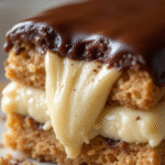 Close-up of a bite of No Bake Chocolate Éclair Cake showing creamy pudding and glossy