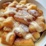 Bread Pudding with Vanilla Sauce Recipe 7 Golden bread pudding drizzled with creamy vanilla sauce on a rustic plate